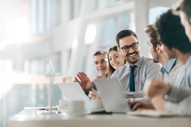 Young happy entrepreneur talking to his colleagues during a business meeting in a board room.